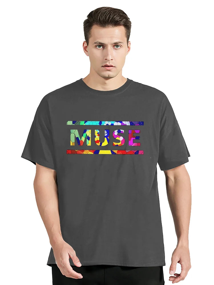 Man wearing a gray t-shirt with 'MUSE' in colorful letters on a white background